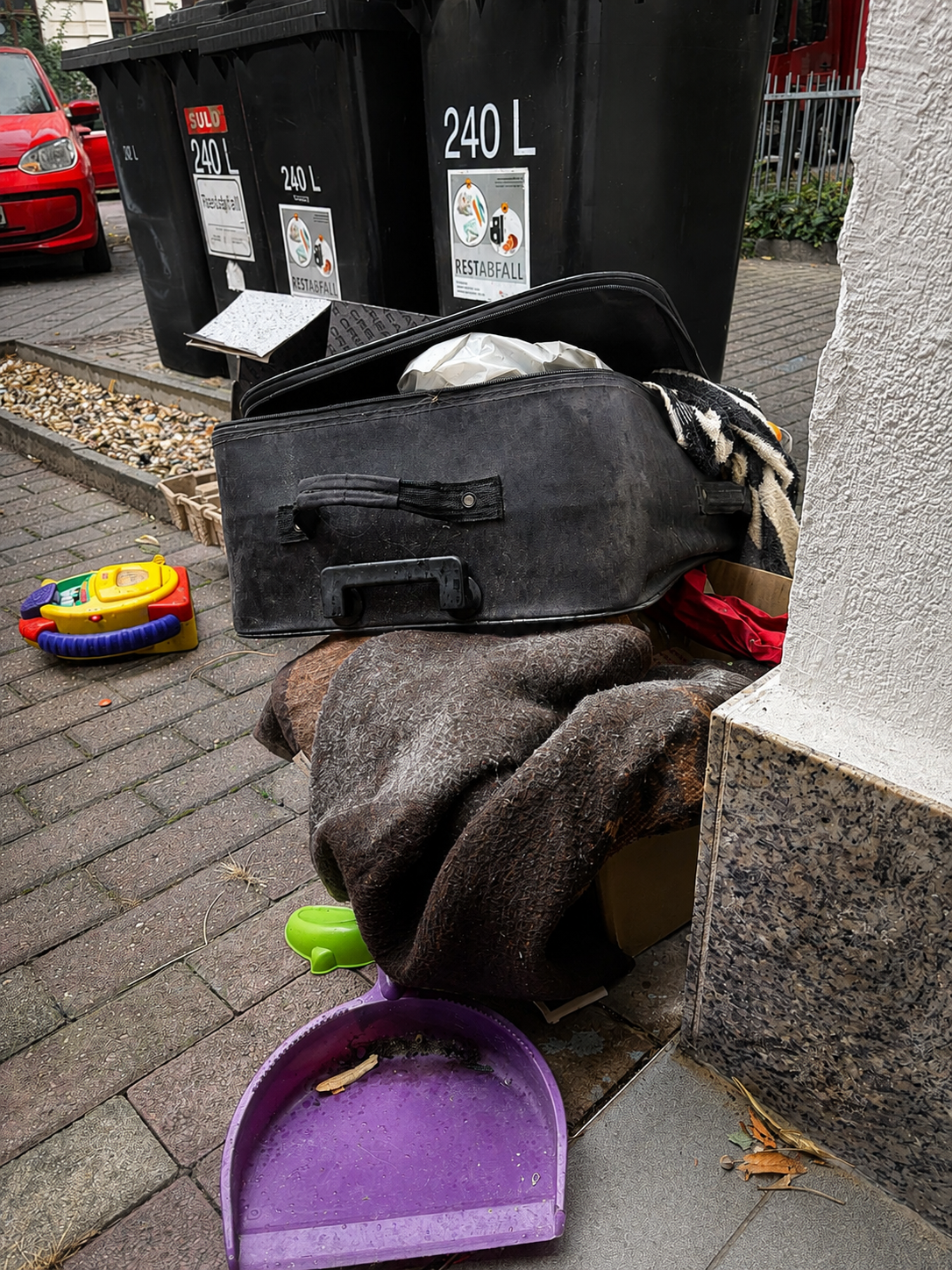 Abgestellte Gegenstände und Müll neben Restmülltonnen in Stadtfeld
