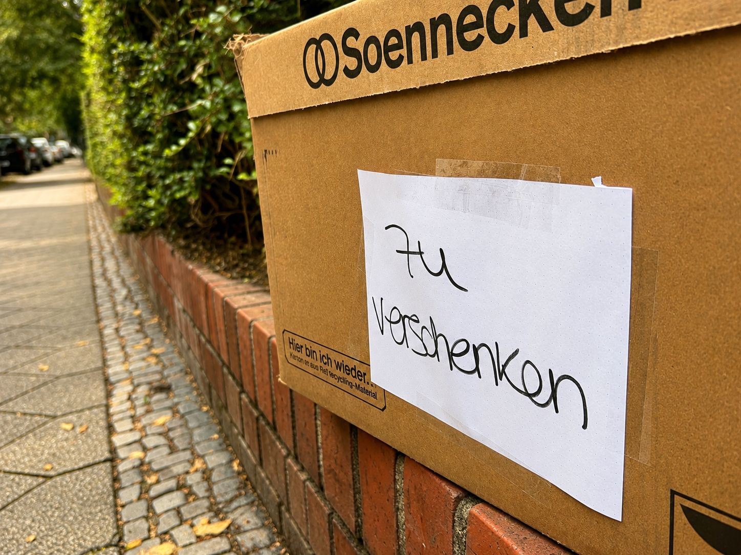 Karton mit dem Hinweis zu verschenken im öffentlichen Raum
